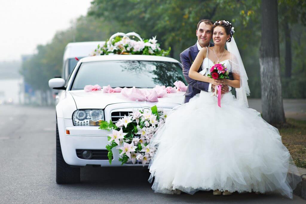 Happy Couple Posing in Front of White Limousine